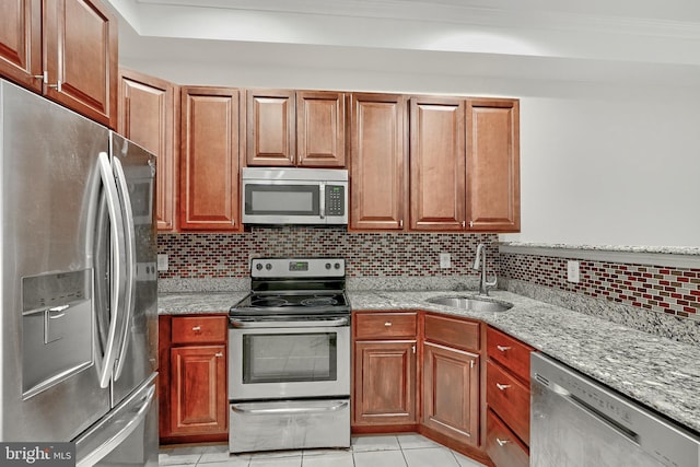 1129 Washington Blvd, Baltimore, MD 21230 - kitchen featuring stainless steel appliances, a sink, light tile patterned flooring, light stone countertops, and tasteful backsplash