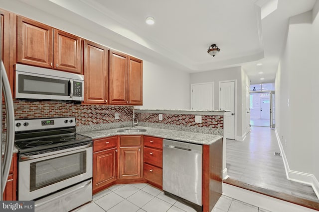 1129 Washington Blvd, Baltimore, MD 21230 - kitchen with appliances with stainless steel finishes, a sink, a peninsula, decorative backsplash, and light tile patterned flooring