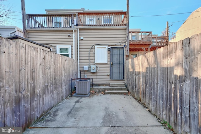 1129 Washington Blvd, Baltimore, MD 21230 - back of property featuring a fenced backyard, a balcony, a patio area, central AC, and entry steps