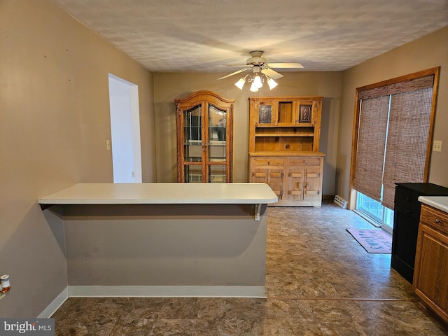 1511 Saint Francis Ln, Altoona, PA 16602 - kitchen featuring ceiling fan, light countertops, a peninsula, baseboards, and a textured ceiling
