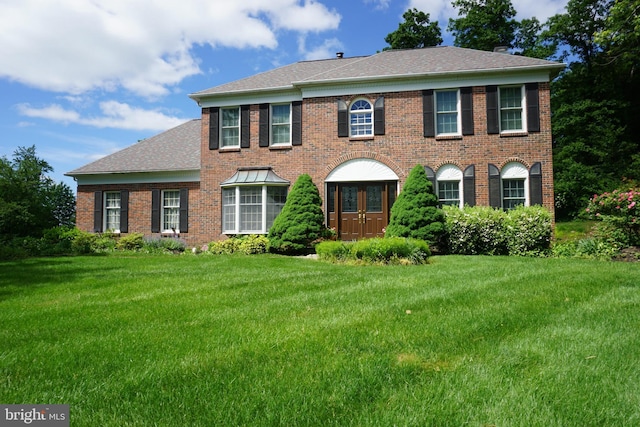 235 Amherst Dr, Doylestown, PA 18901 - colonial house featuring a front yard, brick siding, and a shingled roof