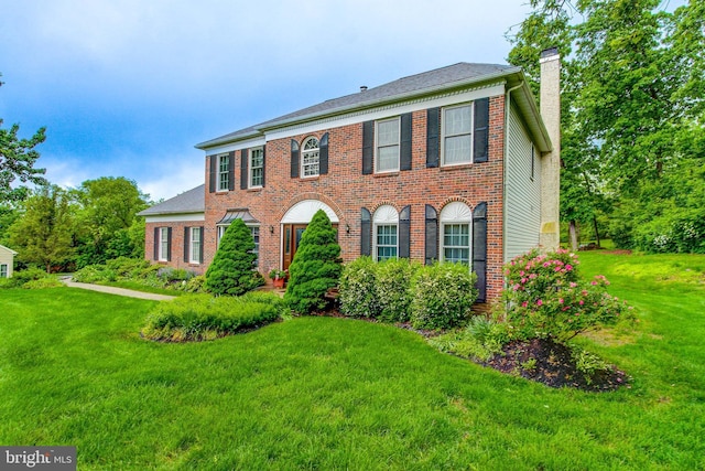 235 Amherst Dr, Doylestown, PA 18901 - colonial-style house featuring a chimney, a front lawn, and brick siding