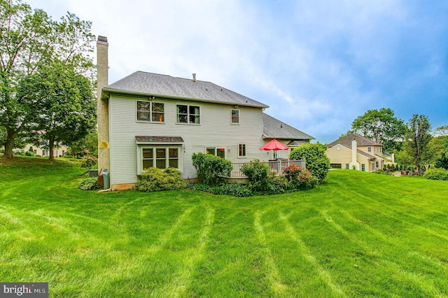 235 Amherst Dr, Doylestown, PA 18901 - back of property with a chimney, a yard, a deck, and a shingled roof