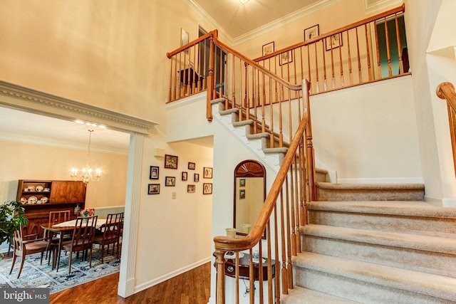 235 Amherst Dr, Doylestown, PA 18901 - stairway featuring wood finished floors, ornamental molding, a chandelier, baseboards, and a high ceiling