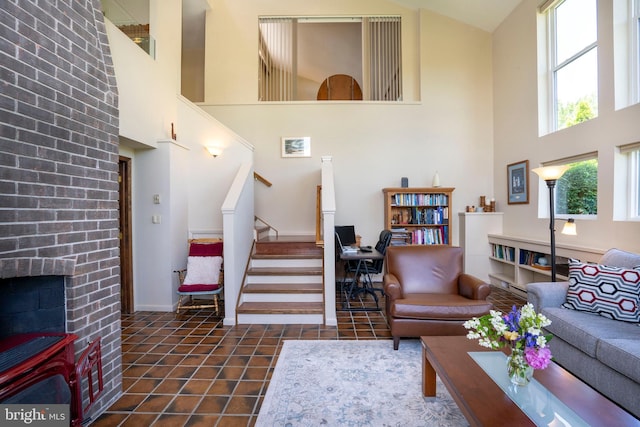 1272 Penfield Rd, State College, PA 16801 - living room featuring a high ceiling, stairway, tile patterned flooring, a fireplace, and baseboards