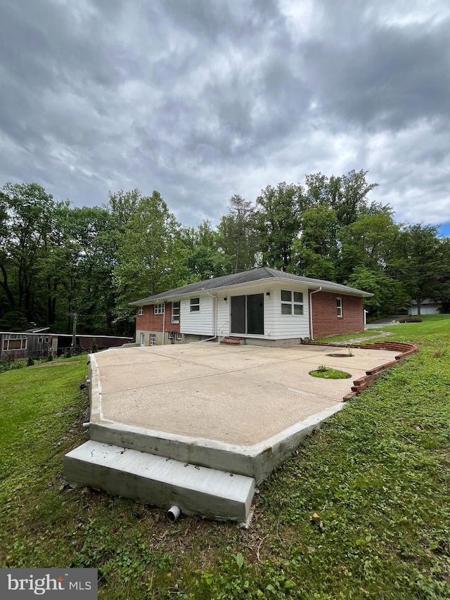905 Dunellen Dr, Towson, MD 21286 - back of property featuring a lawn, view of wooded area, and brick siding