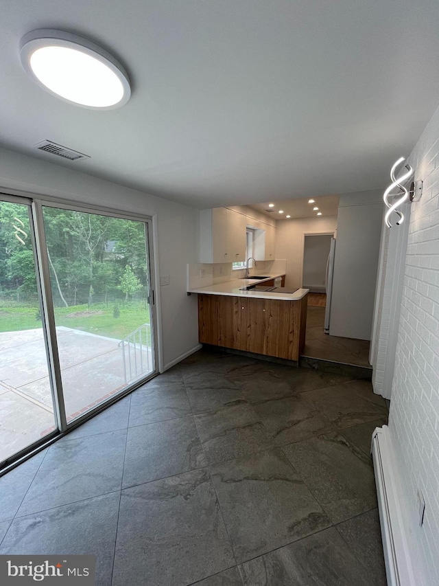 905 Dunellen Dr, Towson, MD 21286 - kitchen featuring a peninsula, freestanding refrigerator, light countertops, a sink, and a baseboard heating unit