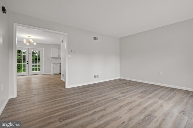 6127 Haymarket Way, Mechanicsburg, PA 17050 - empty room featuring wood finished floors, baseboards, a chandelier, and french doors