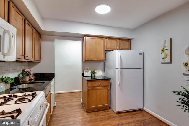6087 Majors Ln Unit 1, Columbia, MD 21045 - kitchen featuring white appliances, backsplash, wood finished floors, baseboards, and a sink