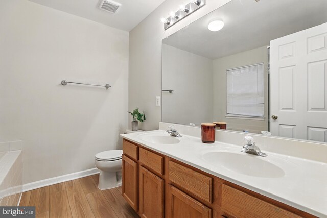 11438 Abner Ave, Fairfax, VA 22030 - bathroom featuring double vanity, wood finished floors, baseboards, and toilet
