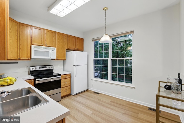 11438 Abner Ave, Fairfax, VA 22030 - kitchen featuring white appliances, a sink, light countertops, light wood-style flooring, and pendant lighting