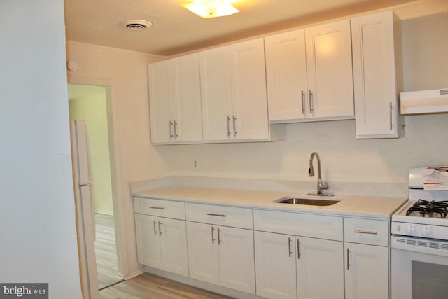 132 Lemmon Ave, Pemberton, NJ 08068 - kitchen featuring white appliances, a sink, under cabinet range hood, white cabinetry, and light countertops