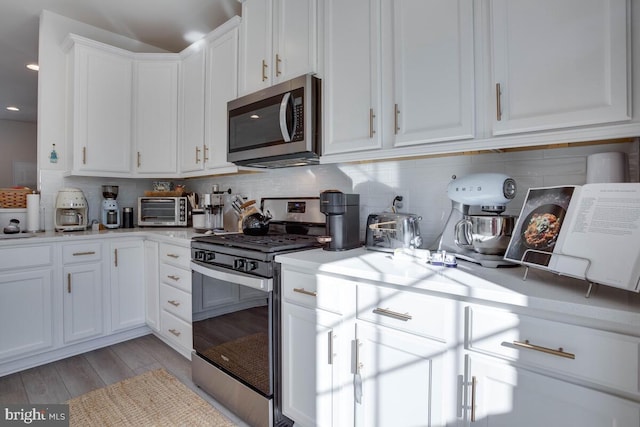 3402 Gentle Breeze Dr, Upper Marlboro, MD 20772 - kitchen with stainless steel appliances, light countertops, light wood-style flooring, white cabinetry, and backsplash