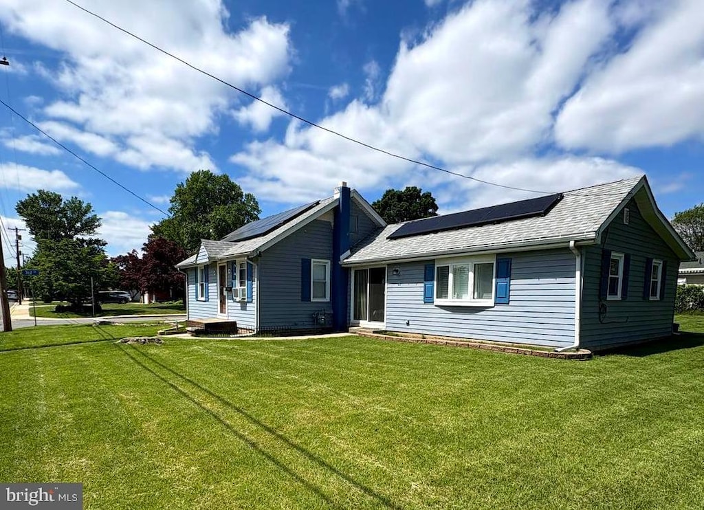 156 Highland Ave, Pennsville, NJ 08070 - view of front of property featuring solar panels, a front yard, and a shingled roof