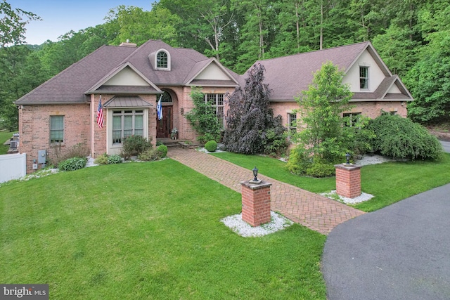 25 Mariner Ct, Ridgeley, WV 26753 - view of front of house with brick siding, a front lawn, roof with shingles, and a view of trees
