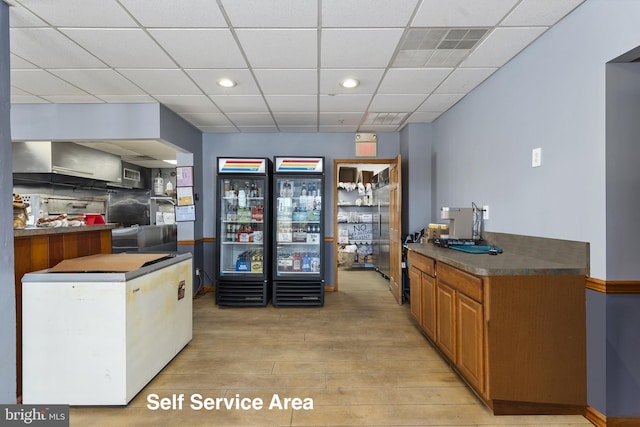 3 Howell Point Rd, Betterton, MD 21610 - kitchen with light wood finished floors, dark countertops, recessed lighting, a drop ceiling, and brown cabinets