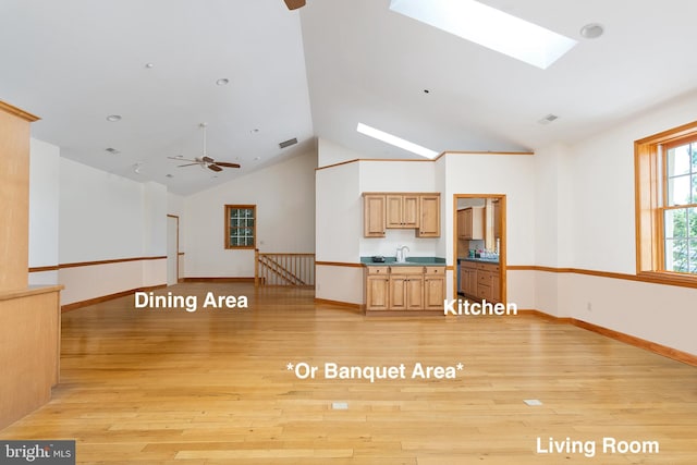 3 Howell Point Rd, Betterton, MD 21610 - unfurnished living room featuring a skylight, vaulted ceiling, ceiling fan, light wood-type flooring, and baseboards