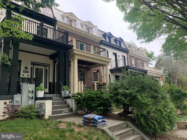 4101 Illinois Ave NW, Washington, DC 20011 - view of front of home featuring a balcony, mansard roof, brick siding, a porch, and a high end roof
