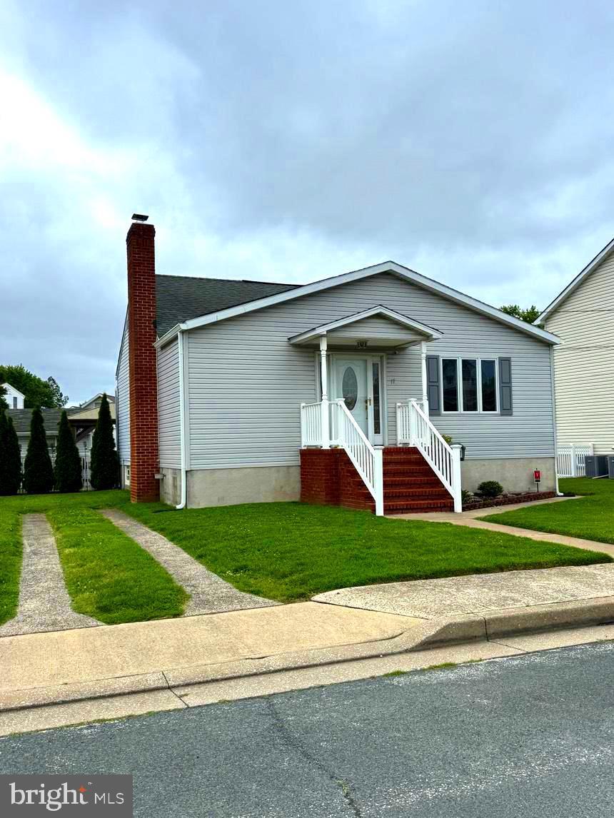 17 Winona Ave, Baltimore, MD 21222 - view of front facade with cooling unit, a front lawn, and a chimney