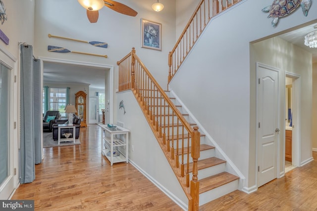 38623 Longs Chapel Ln, Millville, DE 19967 - entryway with stairway, wood finished floors, ceiling fan, baseboards, and a towering ceiling