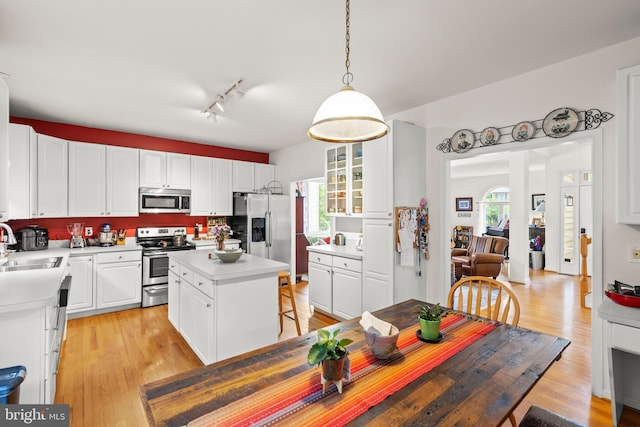 419 Westside Station Dr, Winchester, VA 22601 - kitchen featuring appliances with stainless steel finishes, white cabinets, light countertops, and light wood finished floors