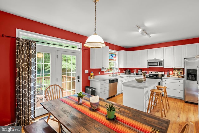 419 Westside Station Dr, Winchester, VA 22601 - kitchen with stainless steel appliances, a sink, white cabinetry, a kitchen island, and light countertops