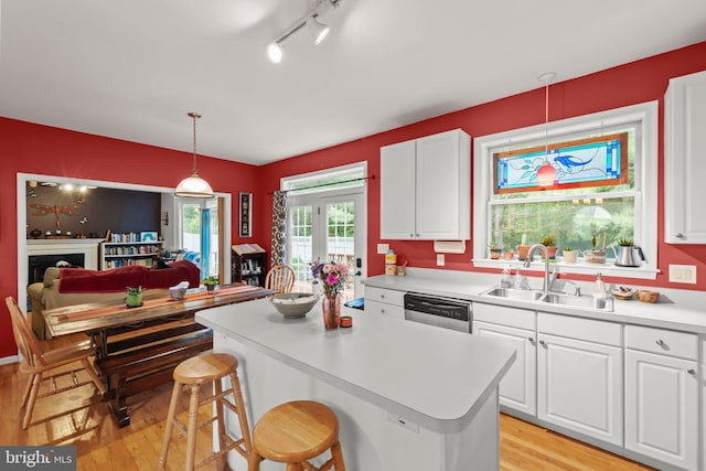 419 Westside Station Dr, Winchester, VA 22601 - kitchen with a sink, stainless steel dishwasher, light wood finished floors, and white cabinetry