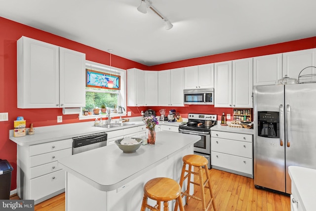 419 Westside Station Dr, Winchester, VA 22601 - kitchen featuring appliances with stainless steel finishes, a sink, light wood-type flooring, and white cabinets