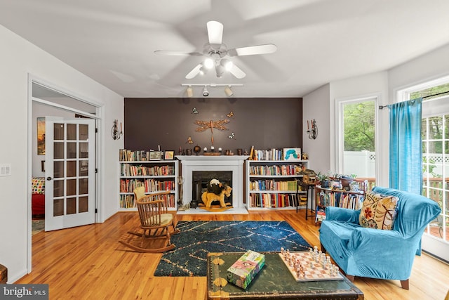 419 Westside Station Dr, Winchester, VA 22601 - living room with wood finished floors, a fireplace with flush hearth, and a ceiling fan