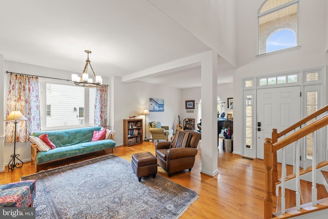 419 Westside Station Dr, Winchester, VA 22601 - living area with healthy amount of natural light, a chandelier, light wood finished floors, and stairs