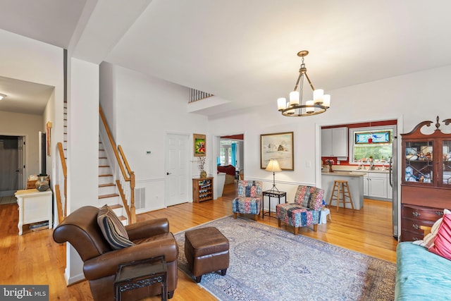 419 Westside Station Dr, Winchester, VA 22601 - living area with light wood-style floors, stairway, and a chandelier