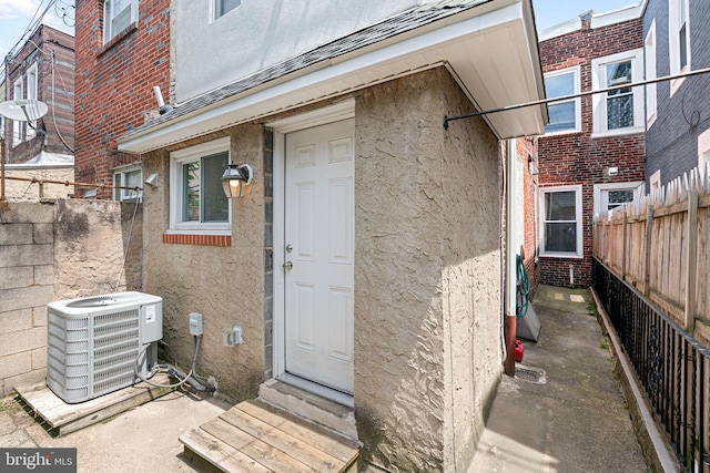 2032 S 21st St, Philadelphia, PA 19145 - doorway to property featuring central air condition unit, stucco siding, and brick siding