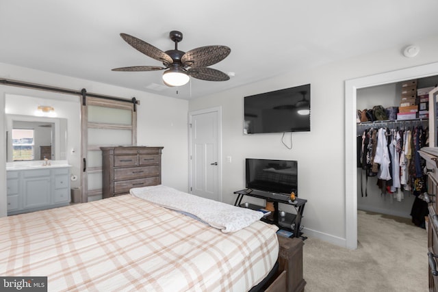 12037 Angora Dr, King George, VA 22485 - bedroom featuring a walk in closet, a closet, a barn door, light colored carpet, and baseboards