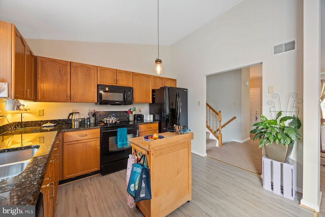 21 Bancroft St, Taneytown, MD 21787 - kitchen with black appliances, high vaulted ceiling, light wood finished floors, pendant lighting, and brown cabinets