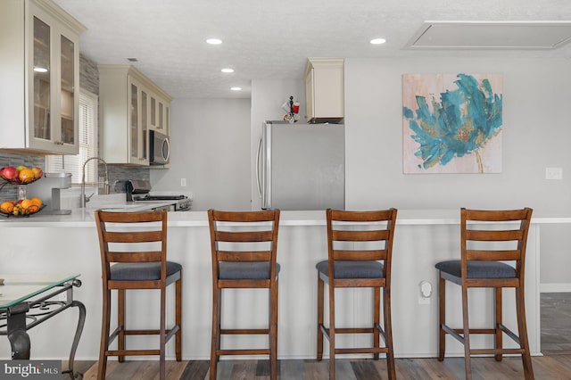 106 Lighthouse Dr, Hampton, VA 23664 - kitchen featuring stainless steel appliances, wood finished floors, glass insert cabinets, light countertops, and a sink