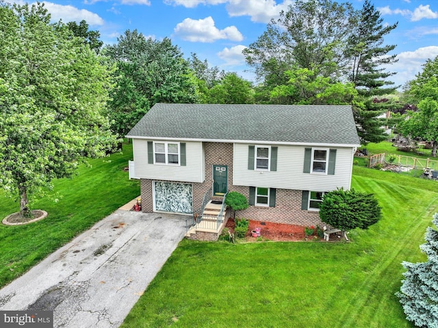 3111 Jessica Rd, Dover, PA 17315 - raised ranch with brick siding, driveway, a front yard, a garage, and roof with shingles