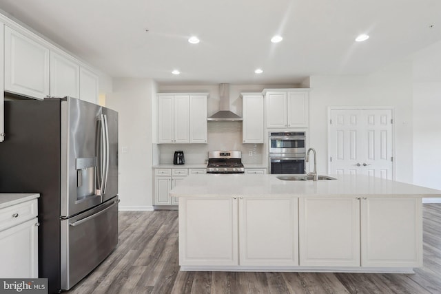11202 King Gallahan Ct, Clinton, MD 20735 - kitchen featuring stainless steel appliances, wall chimney range hood, a sink, white cabinets, and wood finished floors