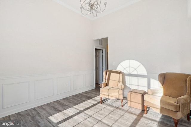 11202 King Gallahan Ct, Clinton, MD 20735 - sitting room featuring a chandelier, light wood-style floors, a wainscoted wall, crown molding, and a decorative wall