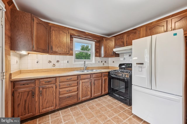 225 Dunlap Rd, Pasadena, MD 21122 - kitchen with white fridge with ice dispenser, gas stove, a sink, under cabinet range hood, and decorative backsplash