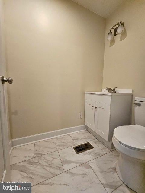 413 10th Ave, Altoona, PA 16602 - bathroom featuring marble look tile flooring, toilet, baseboards, and vanity