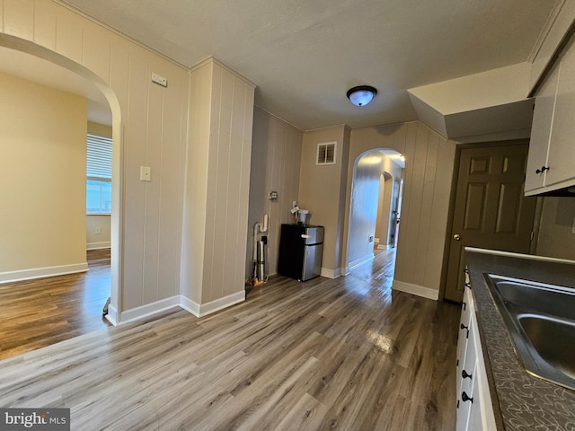 413 10th Ave, Altoona, PA 16602 - kitchen featuring arched walkways, a sink, dark countertops, and wood finished floors