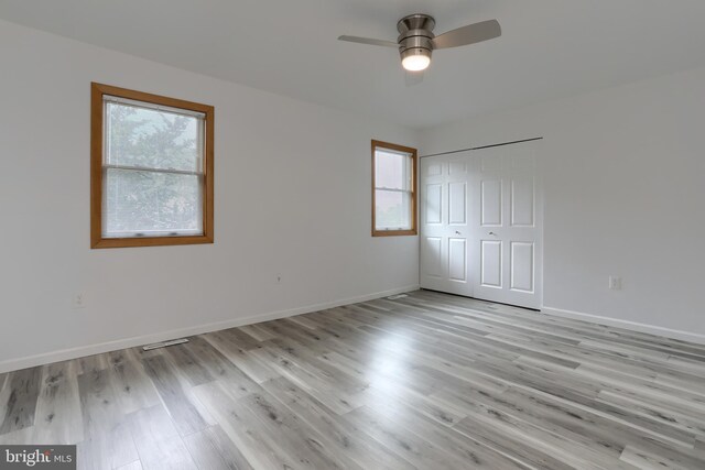 69 Drexel Pl, New Cumberland, PA 17070 - unfurnished bedroom featuring multiple windows, light wood-style floors, baseboards, and a closet