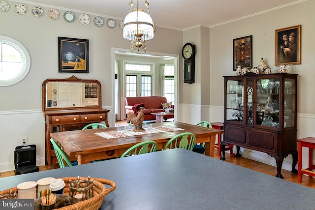 170 Vaughndom Way, Martinsburg, WV 25404 - dining space with healthy amount of natural light, wood finished floors, a chandelier, a wainscoted wall, and crown molding