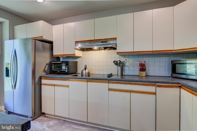 3217 Beech Ridge Dr, Pocono Summit, PA 18346 - kitchen with under cabinet range hood, stainless steel appliances, tasteful backsplash, and dark countertops