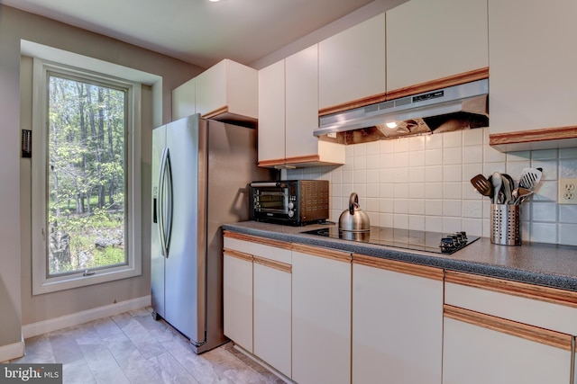 3217 Beech Ridge Dr, Pocono Summit, PA 18346 - kitchen with under cabinet range hood, stainless steel fridge with ice dispenser, black electric cooktop, baseboards, and tasteful backsplash