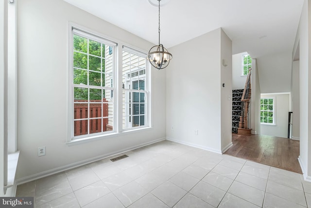 21934 Windover Dr, Broadlands, VA 20148 - unfurnished dining area featuring healthy amount of natural light, a chandelier, baseboards, and tile patterned flooring