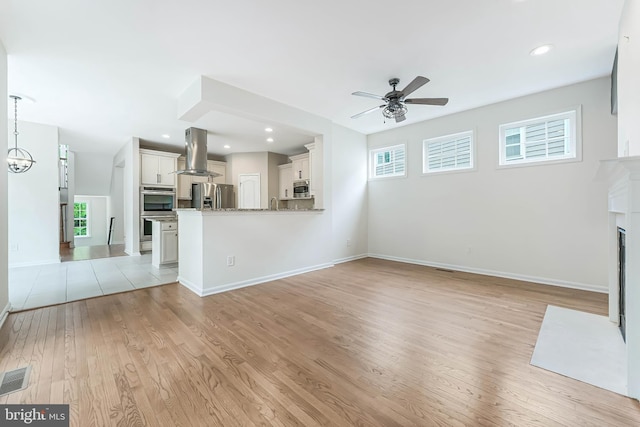 21934 Windover Dr, Broadlands, VA 20148 - unfurnished living room featuring a ceiling fan, light wood-style floors, a fireplace with flush hearth, baseboards, and recessed lighting