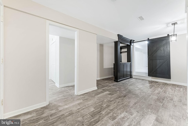 21934 Windover Dr, Broadlands, VA 20148 - empty room featuring a barn door, wood finished floors, and baseboards