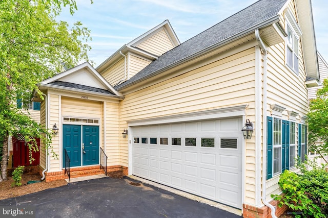 21934 Windover Dr, Broadlands, VA 20148 - view of property exterior featuring driveway, roof with shingles, an attached garage, and entry steps