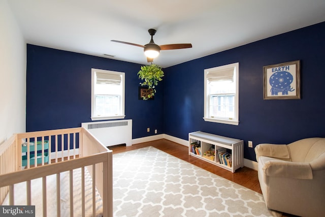 6306 Blackburn Ct, Baltimore, MD 21212 - bedroom featuring radiator, multiple windows, wood finished floors, and baseboards